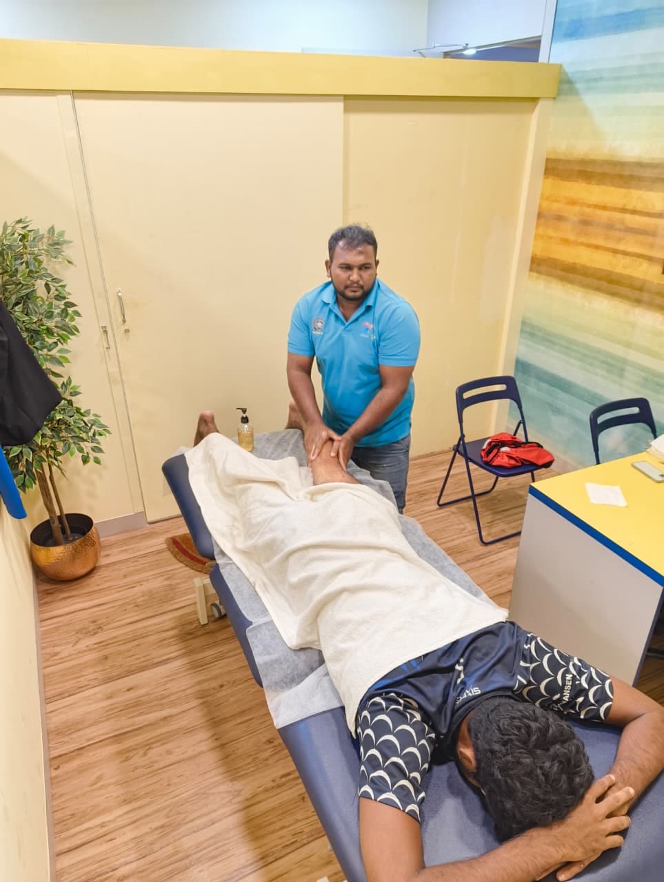 Sports massage therapist R. Arunraj treating an athlete's leg during a recovery session